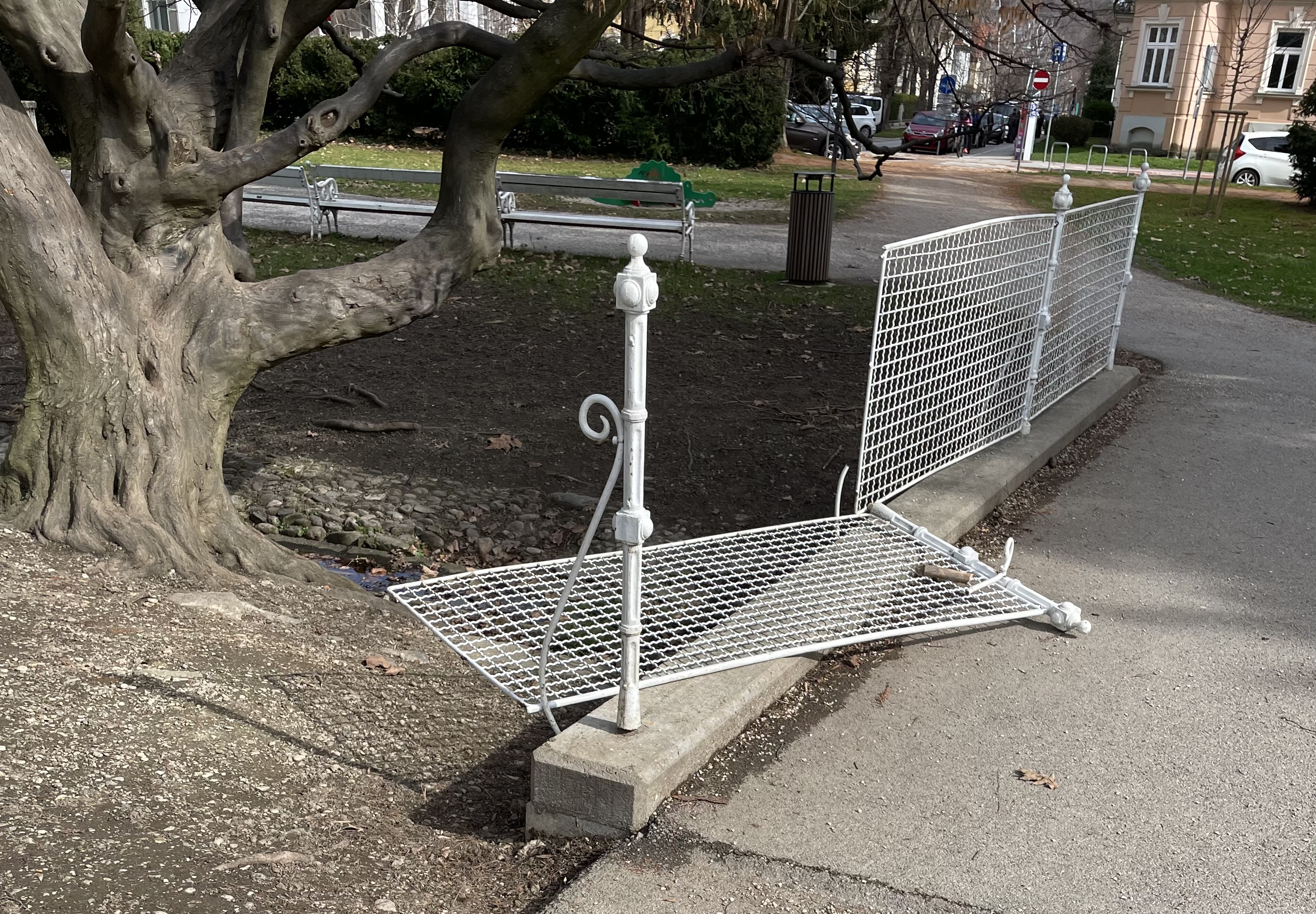 Poškodovana klop in ograja v Mestnem parku